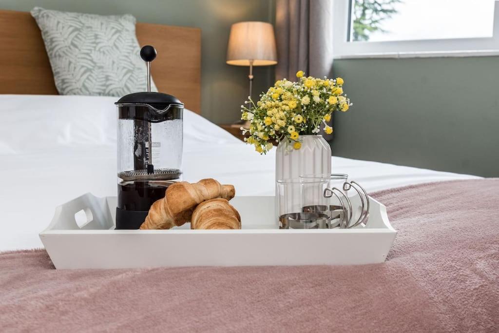 a tray with a coffee maker and pastries on a bed at Ivy House in Northampton