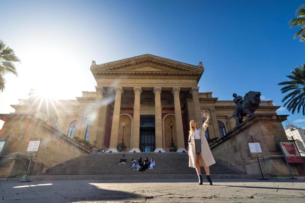a woman standing in front of a building at Residenze Chamur- Grattacielo in Palermo