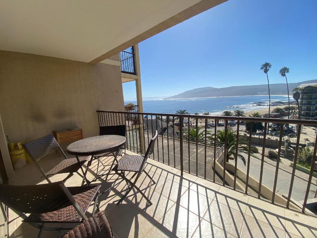 einen Balkon mit einem Tisch, Stühlen und Meerblick in der Unterkunft Hermoso y amplio depto con vista al mar y playa in Papudo