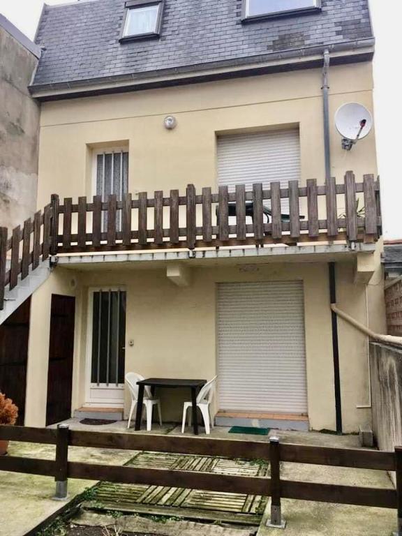 une maison avec une terrasse avec une table et des chaises dans l'établissement Ma cour Berck/mer, à Berck-sur-Mer