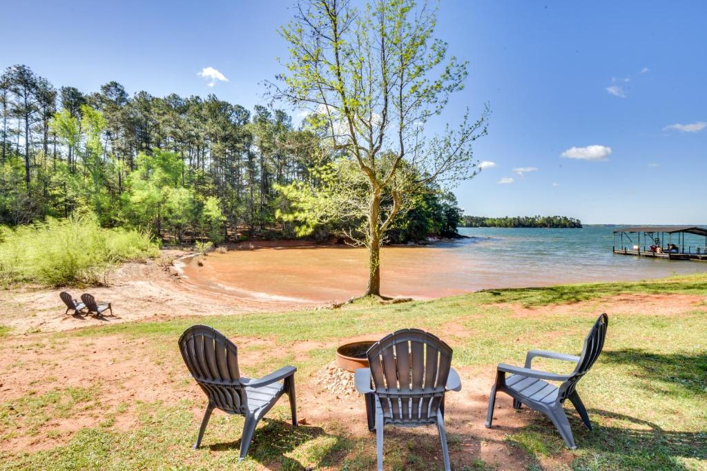 3 Stühle und ein Tisch am Ufer eines Sees in der Unterkunft Starr Rental on Lake Hartwell Deck and Water View! 
