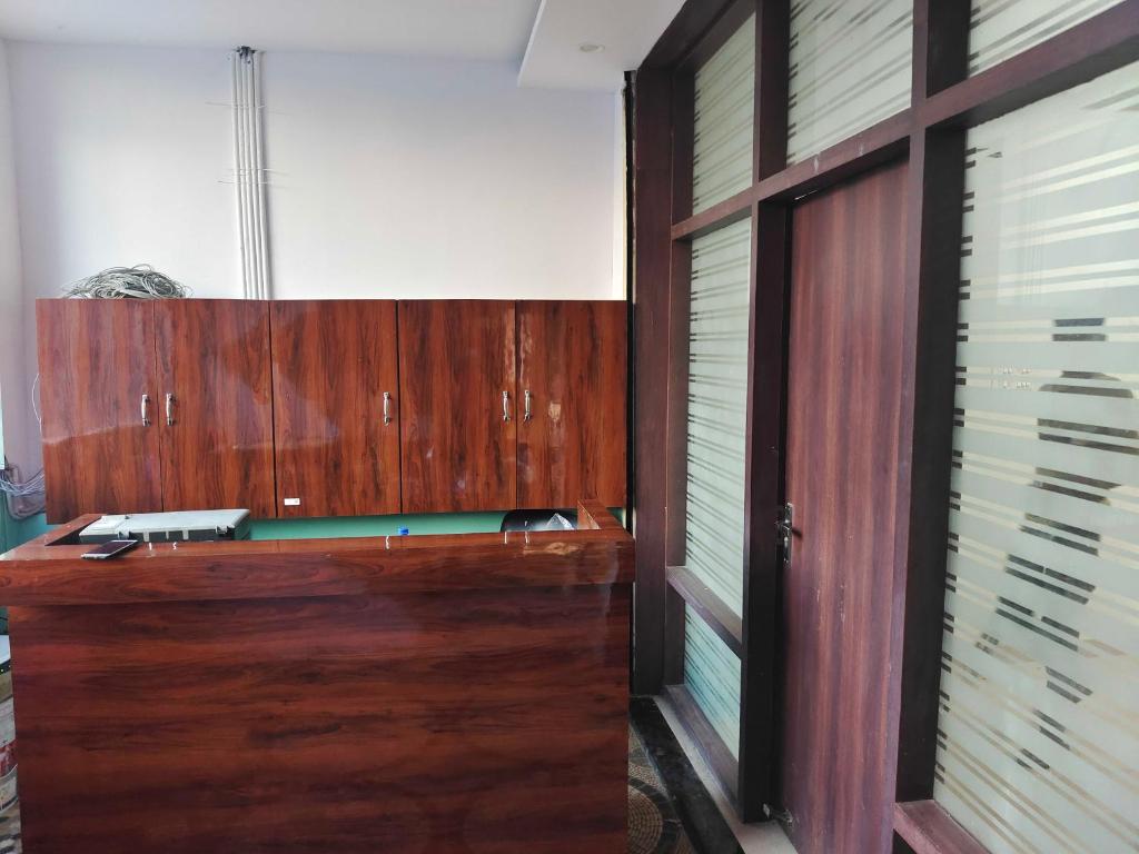 een houten bureau in een kamer met een raam bij OYO Flagship Hotel Shaurya in Gorakhpur