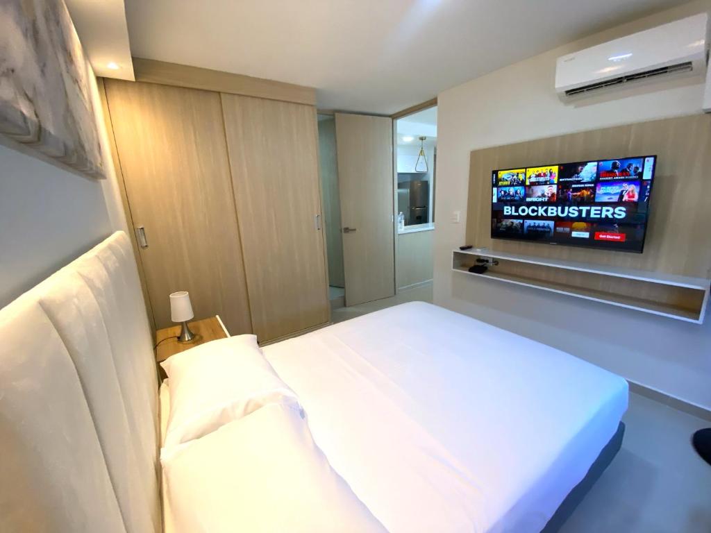 Habitación de hotel con cama y TV en Apartamentos Mirador - Excelente Ubicacion by SOHO, en Barranquilla