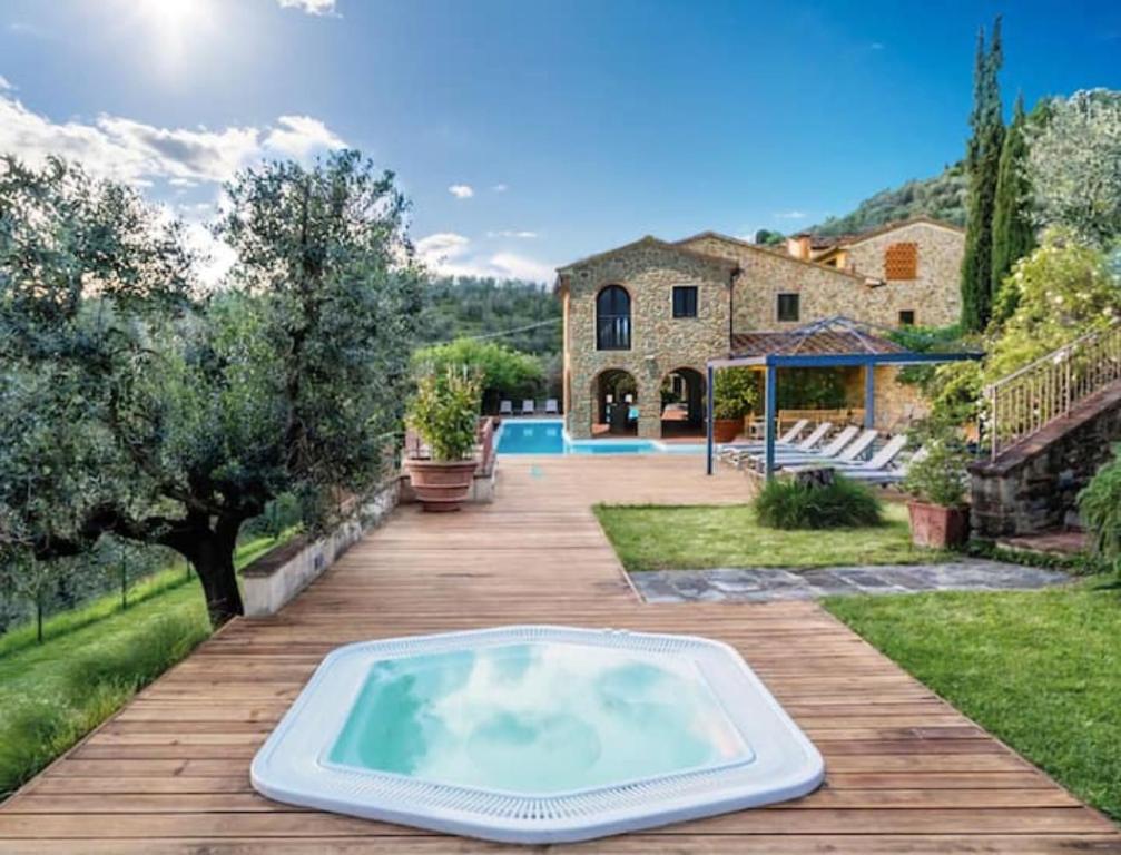 - une piscine sur une terrasse en bois avec une maison dans l'établissement Borgo in Montalbano by Secret Hills, à Larciano