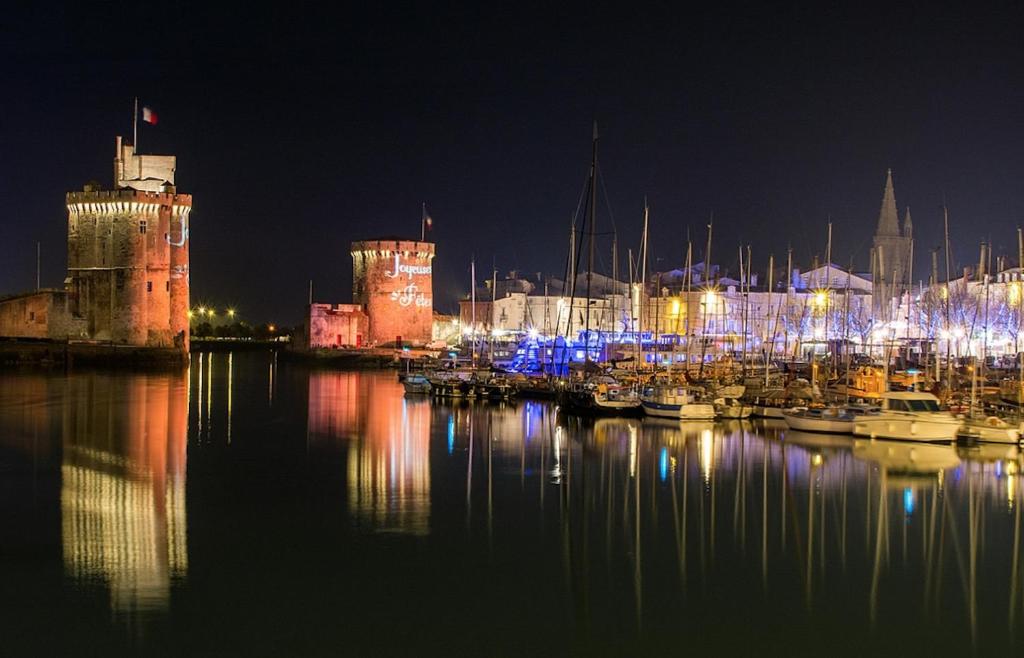 un port avec des bateaux dans l'eau la nuit dans l'établissement Devant les grands chalutiers, à La Rochelle