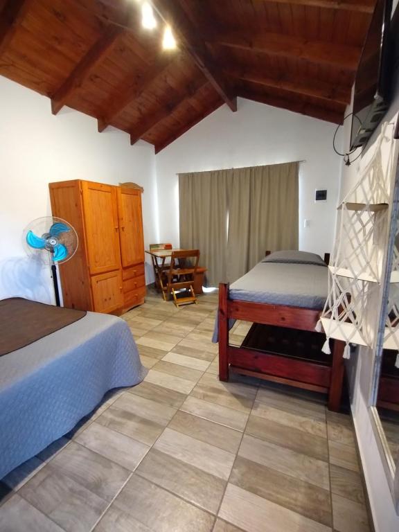 a bedroom with two beds and a table at Las Marilubis Calamuchita in Santa Rosa de Calamuchita