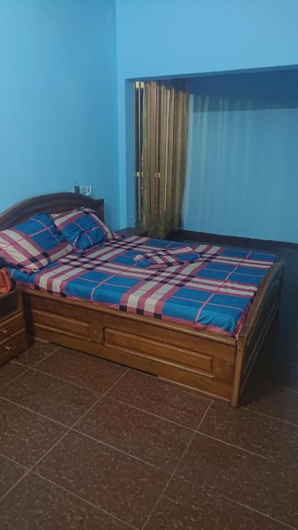 een bed in een kamer met een blauwe achtergrond bij Résidence la Lobe in Kribi