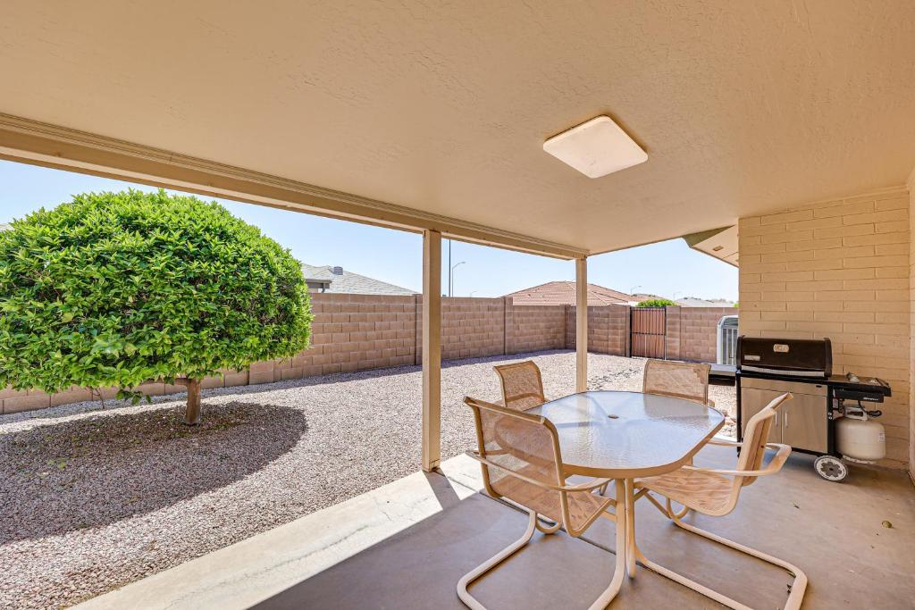 Mesa Home in 55 and Community with Patio and Gas Grill! في ميسا: فناء مع طاولة وكراسي وشجرة