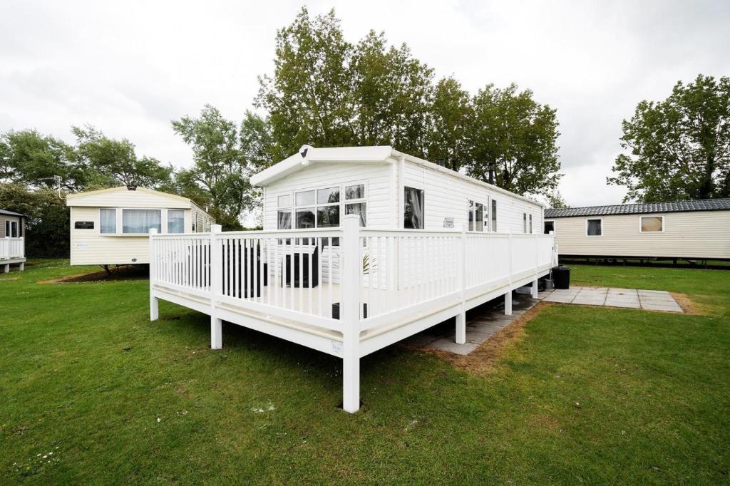 a large white mobile home in a yard at Mendip Close in Burnham on Sea