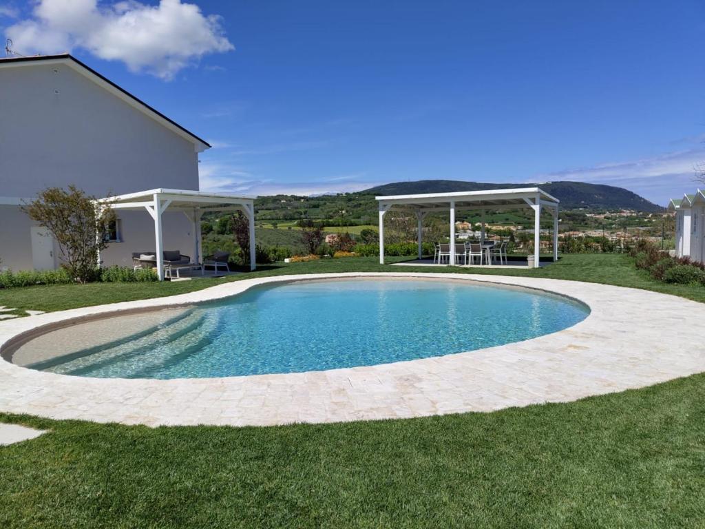 a swimming pool in the yard of a house at Le Nereidi Green Resort Elisa in Sirolo
