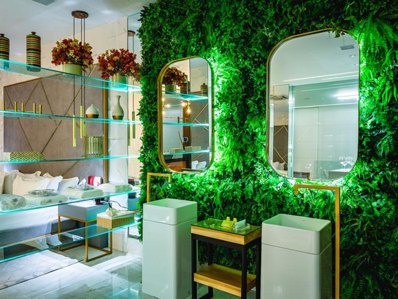 uma casa de banho com uma parede verde com dois espelhos em Corinto Hotel no Rio de Janeiro