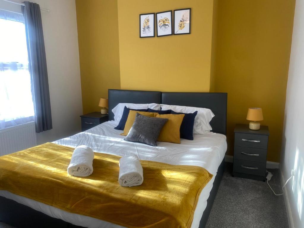 a bedroom with a large bed with towels on it at Spacious 3BR House Near Southend Pier in Southend-on-Sea