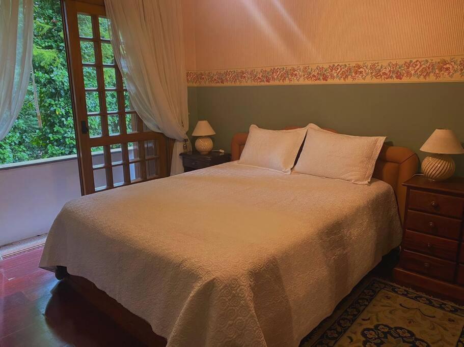 Un dormitorio con una cama grande y una ventana en Apartamento aconchegante Gramado, en Gramado