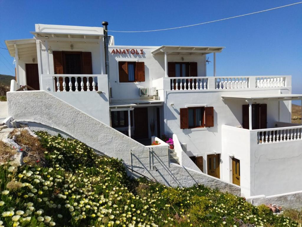 a white building with stairs in front of it at ANATOLI ROOMS SERIFOs in Serifos Chora