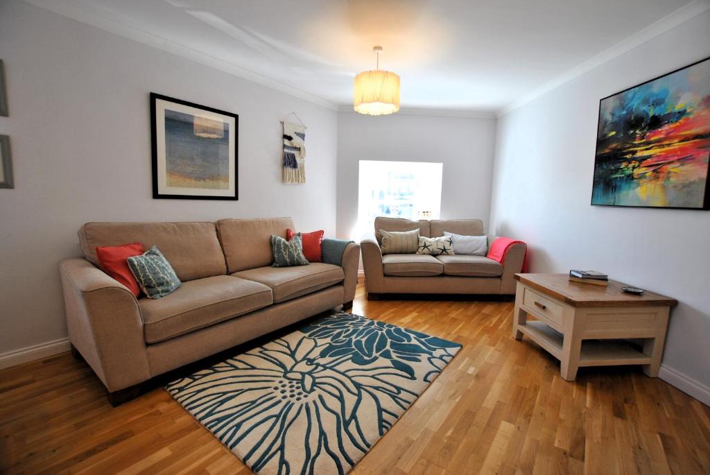 a living room with a couch and a table at Coorie Cottage- stylish townhouse Anstruther in Anstruther