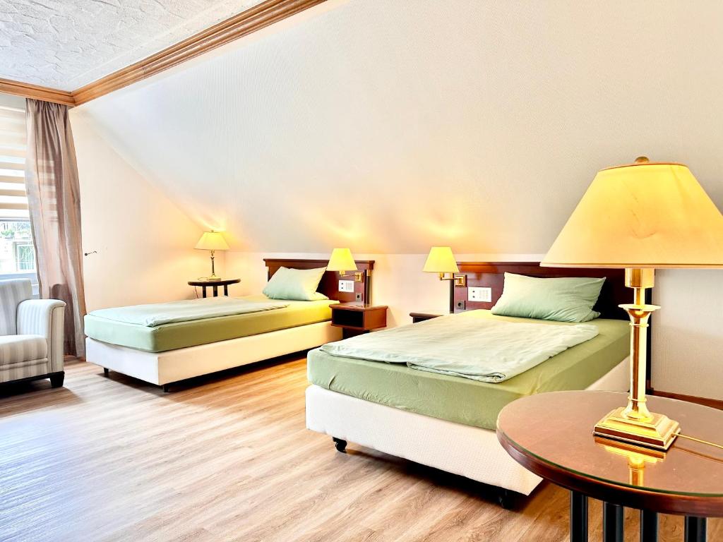 ein Hotelzimmer mit zwei Betten und einem Tisch in der Unterkunft Ferienwohnung 2-4 Pers WLAN und Parkplatz, HDZ und Kliniken in der Nähe, direkt an der A2 und A30 gelegen in Löhne