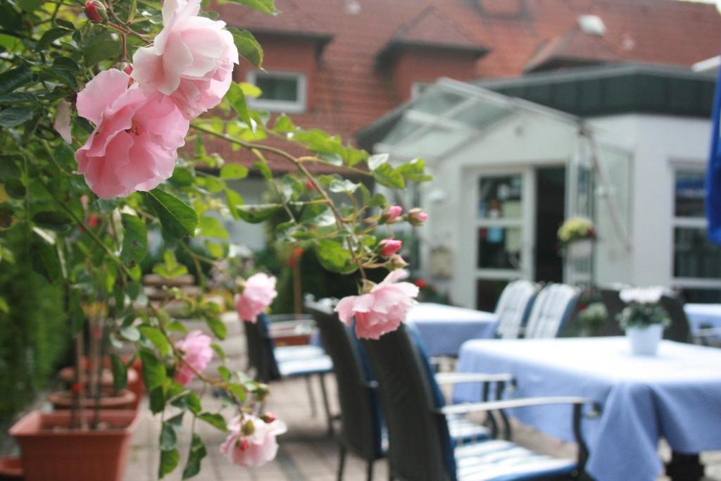 マールブルク・アン・デア・ラーンにあるHotel-Restaurant Fasanerieのピンクの花のテーブルと椅子