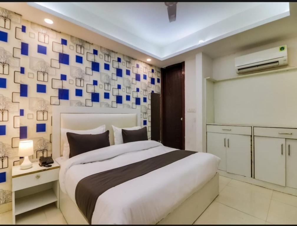 a bedroom with a large bed with blue squares on the wall at Hotel Galaxy Stay B&B in New Delhi