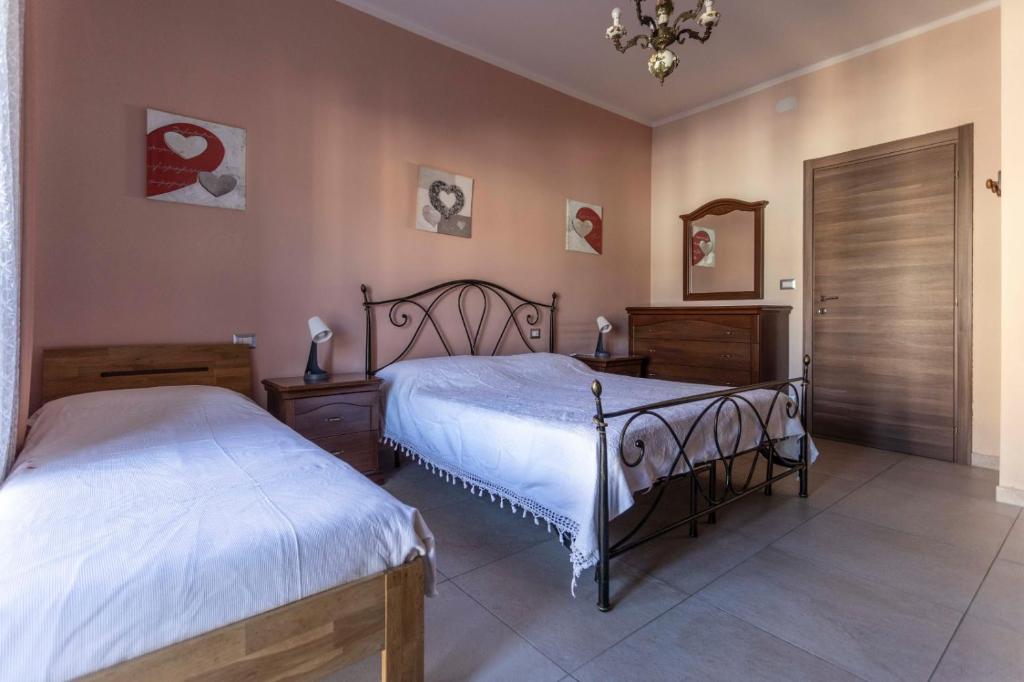 a bedroom with two beds and a mirror at Little's Venaria in Venaria Reale