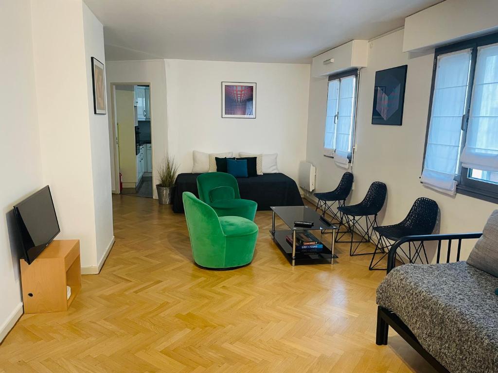 un salon avec un canapé, des chaises et une télévision dans l'établissement Beautiful 45 m2 private apartment in Paris Montparnasse, à Paris