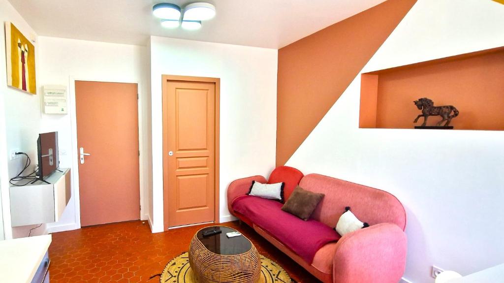 ein Wohnzimmer mit einer roten Couch in einem Zimmer in der Unterkunft Appartements Marseille cours Julien in Marseille