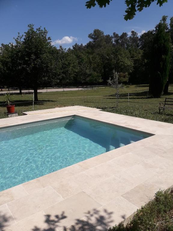 une piscine au milieu d'une cour dans l'établissement Chez Nathalie, au Luc