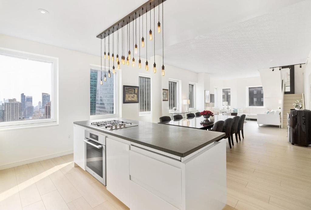 una cucina bianca con piano di lavoro e un soggiorno di Luxury 5 Bedroom Apartment Manhattan NYC a New York