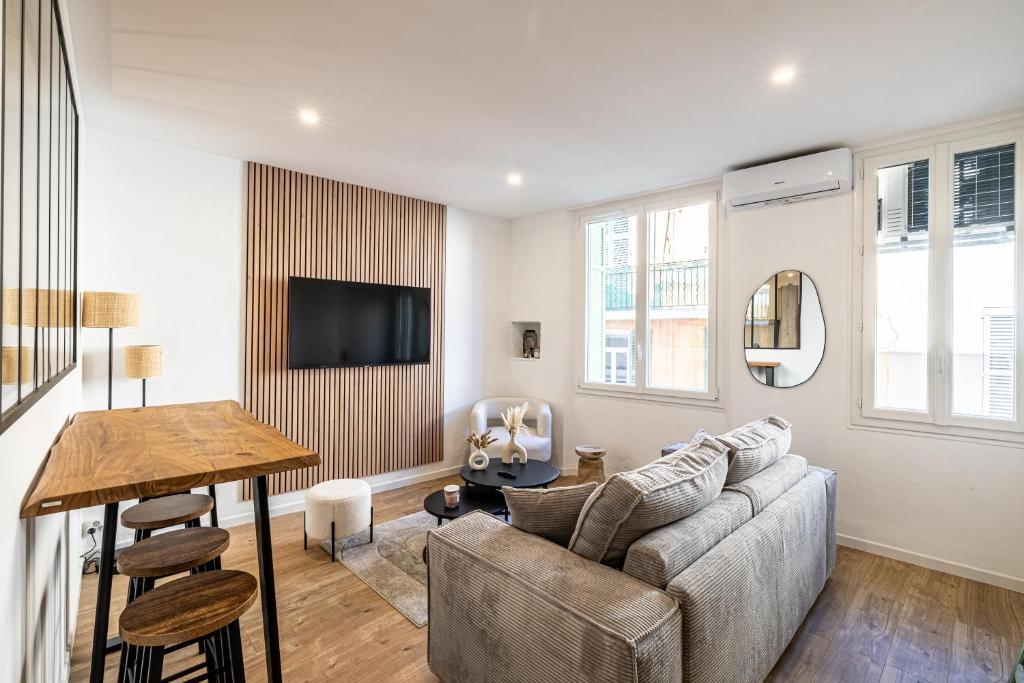 un salon avec un canapé et une table dans l'établissement 5 SUQ - Splendide appartement rénové proche Palais et plages, à Cannes