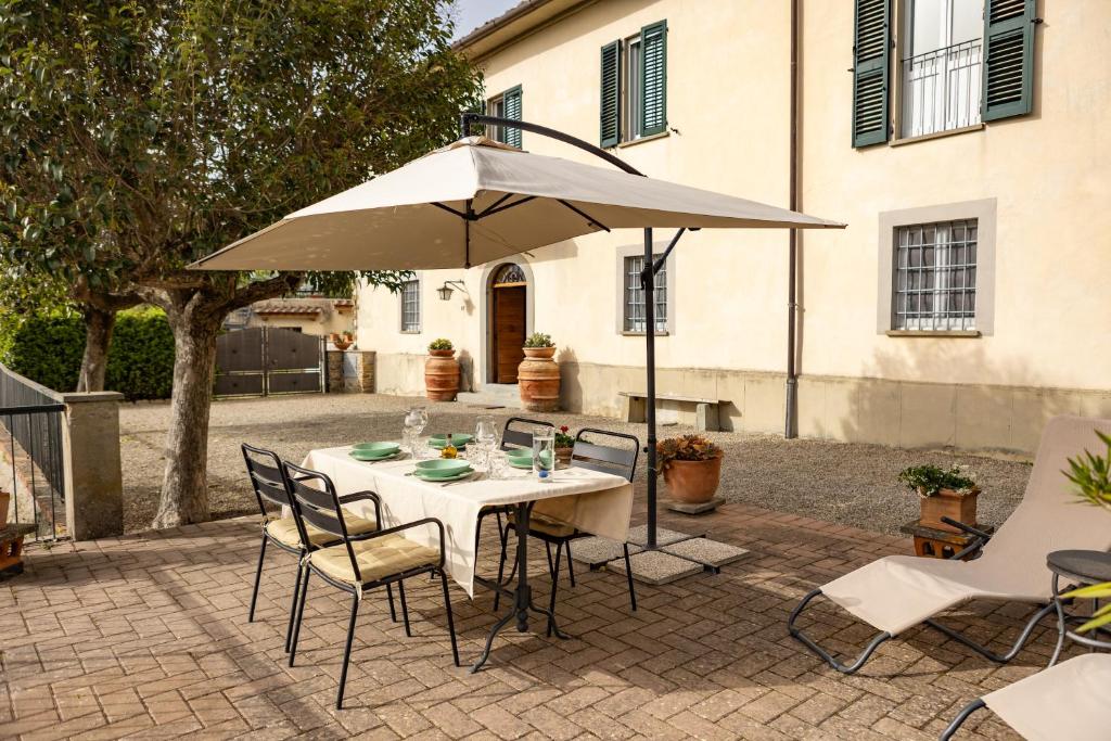 a table with an umbrella on a patio at Villa Medici Donnini in Arezzo