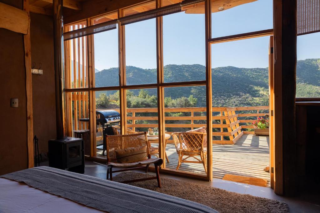 a bedroom with a bed and a view of a deck at Origen del Maipo Lodge in San José de Maipo