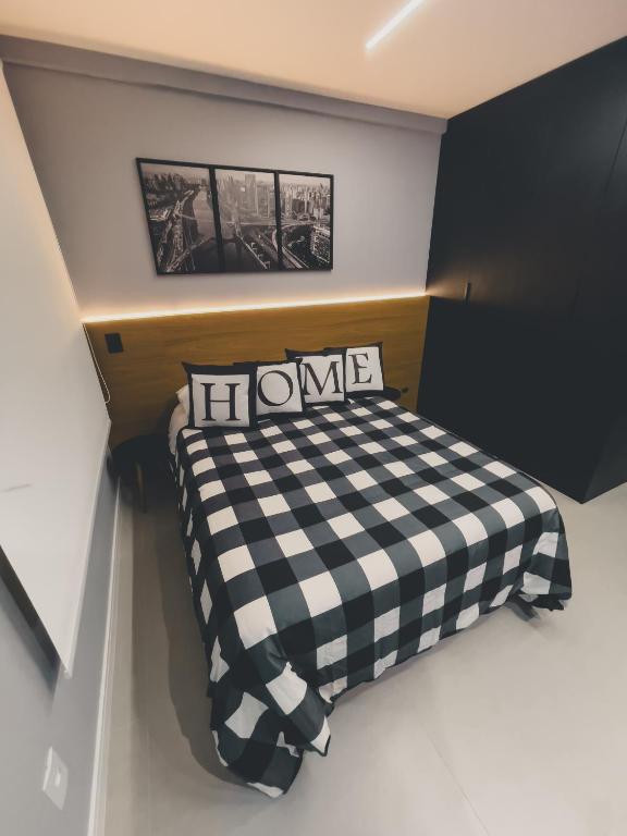 a small bedroom with a black and white checkered bed at Studio Vila Madalena Mirant in São Paulo