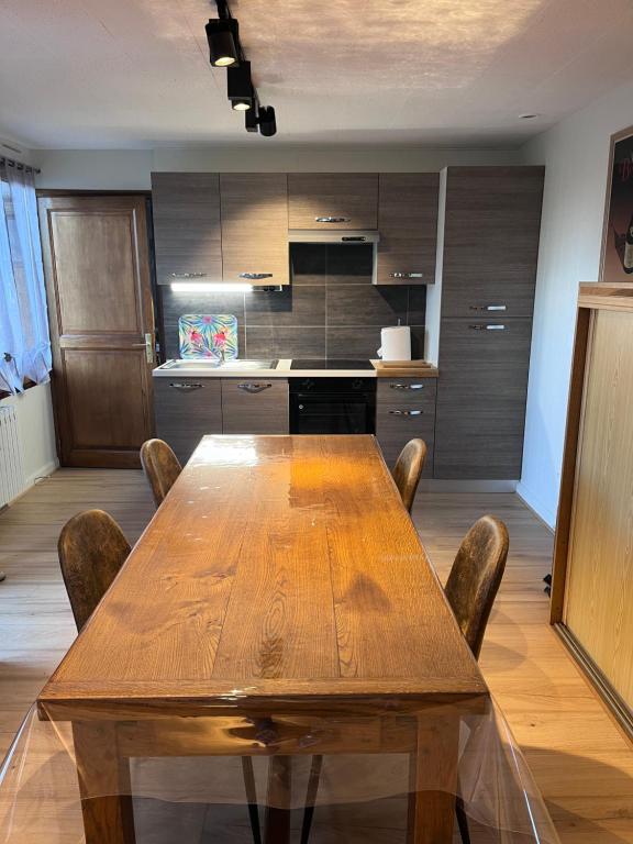 einen Holztisch und Stühle in der Küche in der Unterkunft Cottage Apolline in Santenay