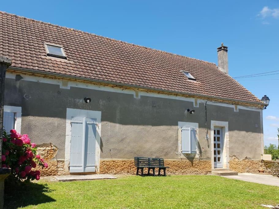 dom z ławką przed nim w obiekcie Maison de campagne en Périgord noir w mieście Nadaillac