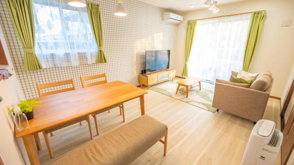 uma sala de estar com uma mesa, um sofá e uma televisão em BLUE SOLARE 2 - Vacation STAY 14648v em Ilhas Miyako