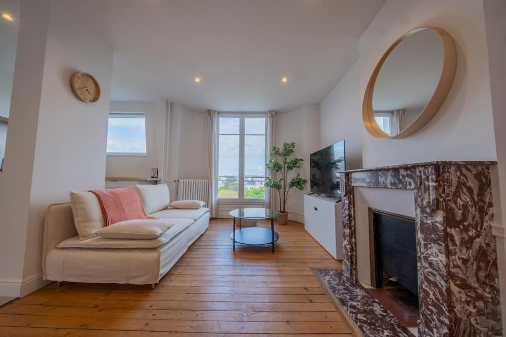 un salon avec un canapé et une cheminée dans l'établissement Sommet Remois Cathedrale, à Reims