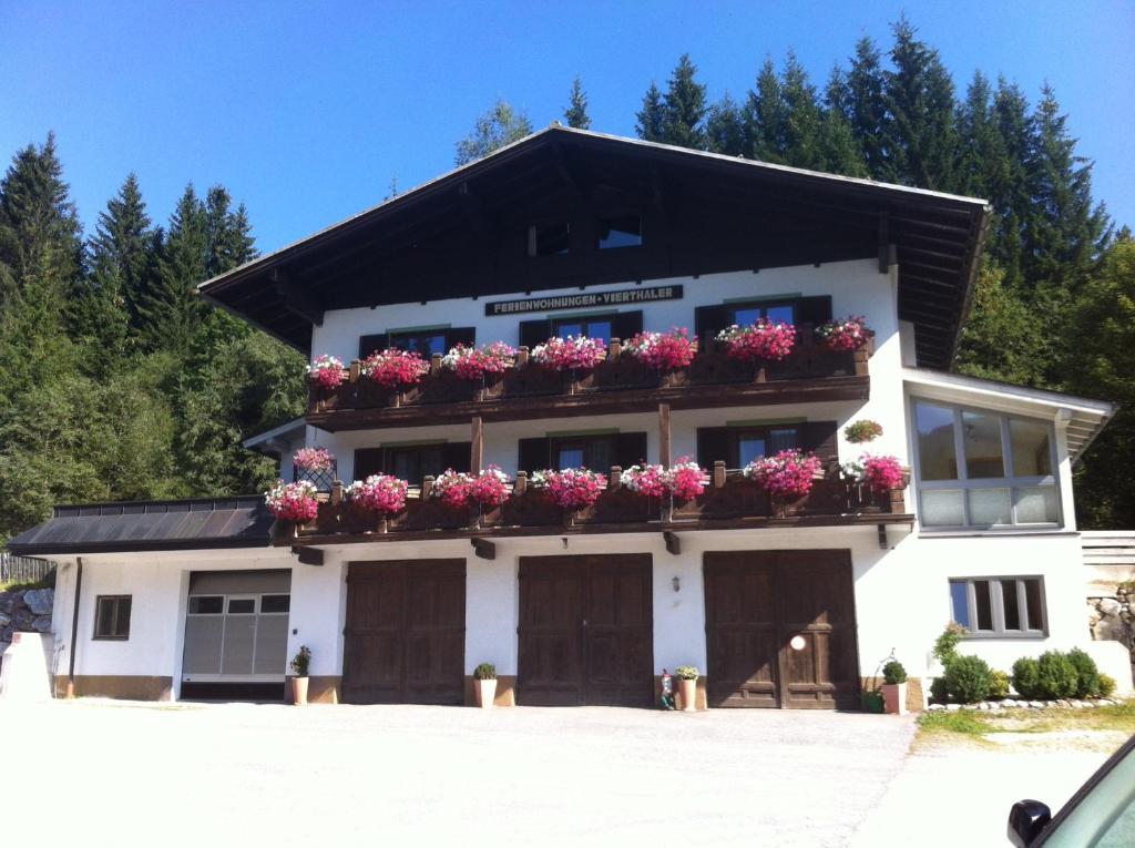 ein weißes Gebäude mit Blumenkästen drauf in der Unterkunft Ferienwohnungen Vierthaler in Filzmoos