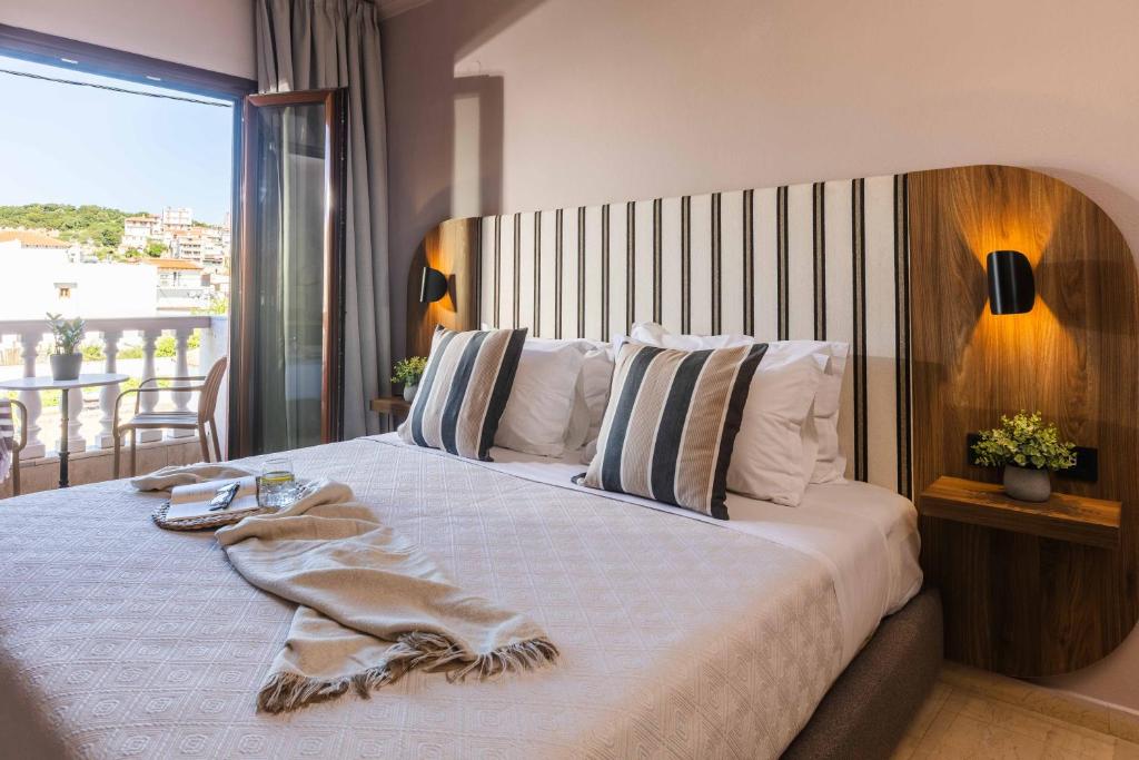 a bedroom with a large bed with a large window at Casa Blue Hotel, Philian Hotels and Resorts in Skiathos