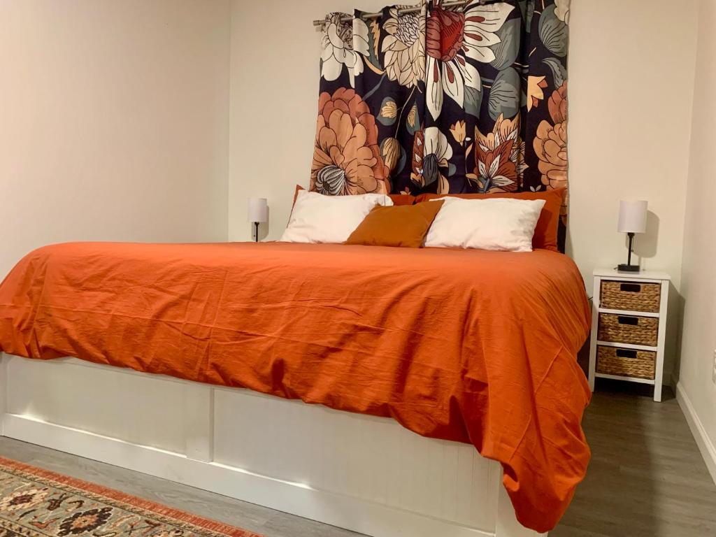 a bedroom with a bed with an orange blanket at The Asbury House Guest Rentals in Moscow