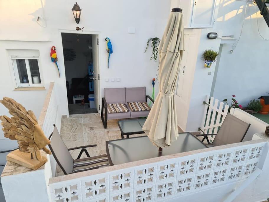 a living room with a patio umbrella and chairs at El Faro del Manteca in Cádiz