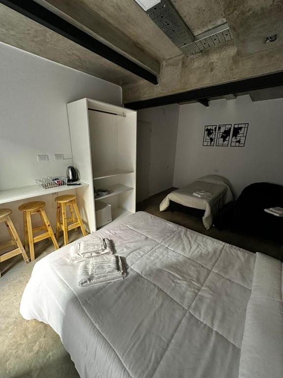 a bedroom with a white bed and a refrigerator at DOCTA RESIDENCIA in Cordoba