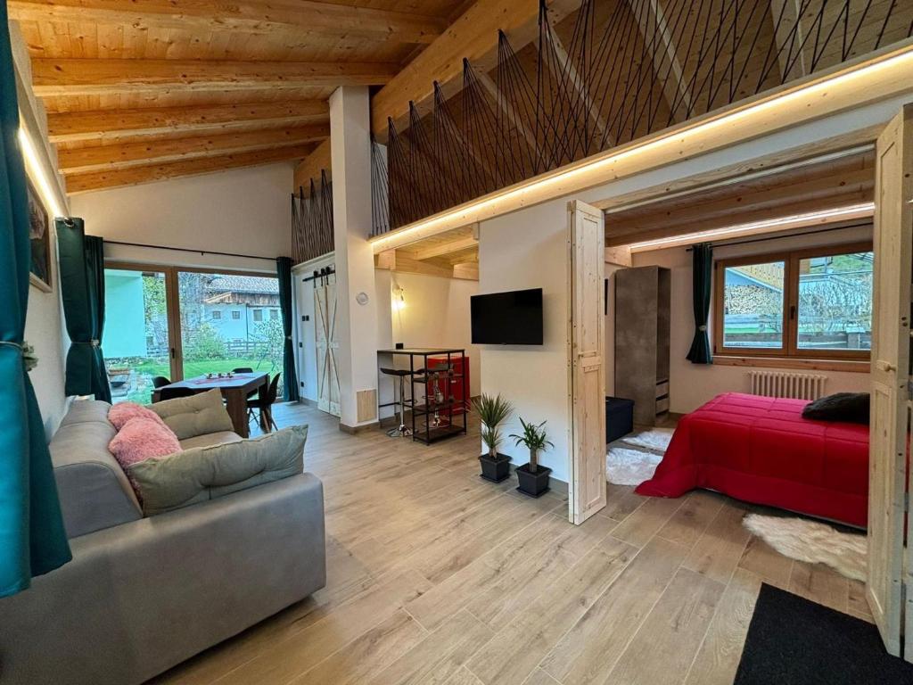 ein Wohnzimmer mit einem Sofa und einem Bett in der Unterkunft Casetta Vanda in Santo Stefano di Cadore