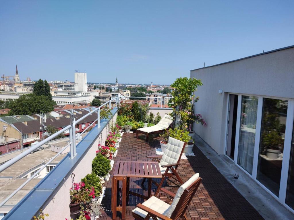 - un balcon avec des chaises et des tables dans un bâtiment dans l'établissement Penthouse apartment, à Novi Sad