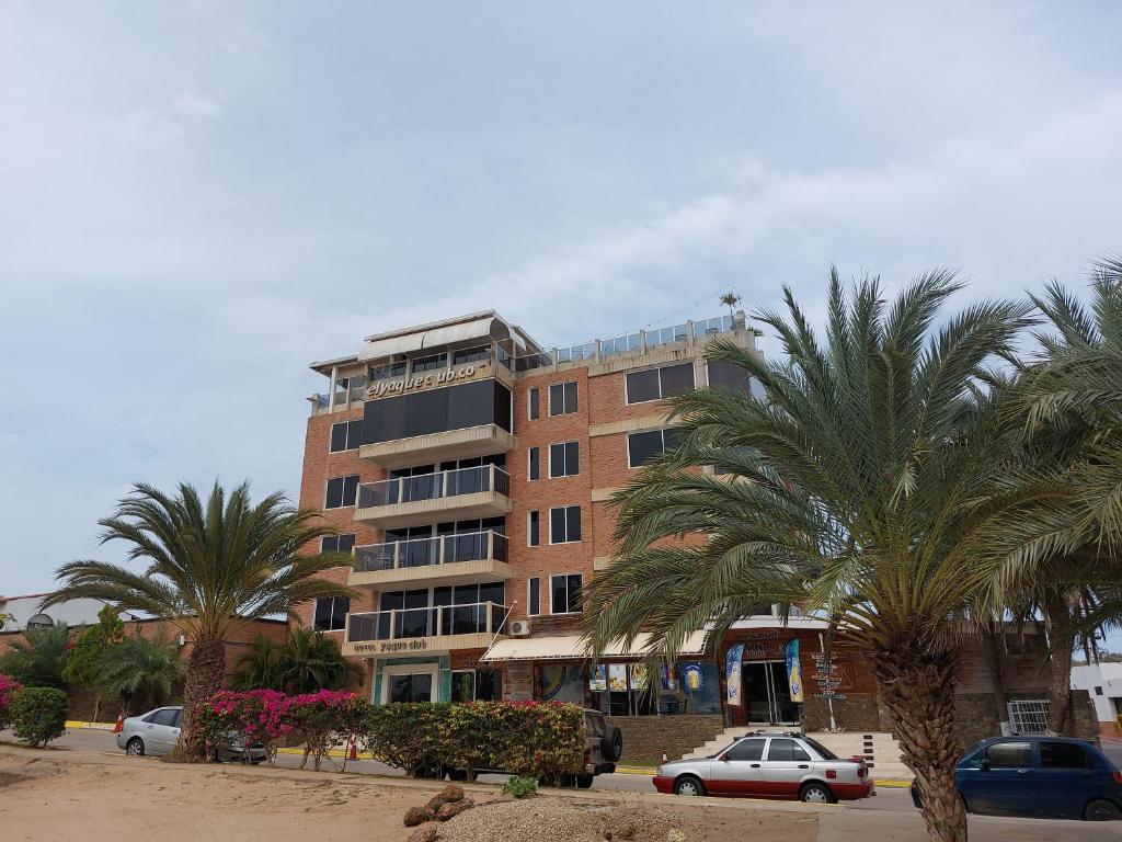 a tall building with palm trees in front of it at Hotel Yaque Club in Porlamar