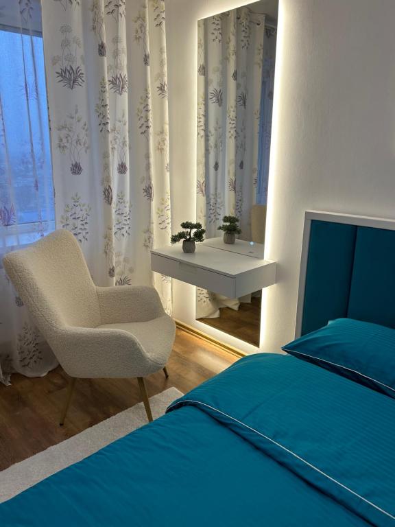 ein Schlafzimmer mit einem Bett, einem Stuhl und einem Fenster in der Unterkunft 2-к Люкс в центре in Tscherkassy