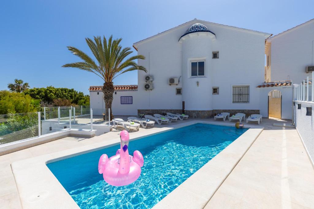 einen Pool mit einem rosa aufblasbaren Flamingo in einem Haus in der Unterkunft Fidalsa Grand Mediterranean Beachfront in Playa Flamenca