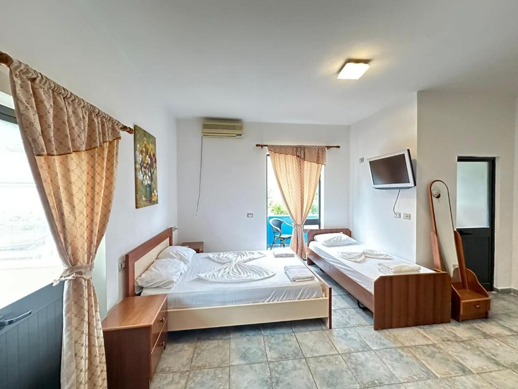 1 dormitorio con 2 camas y TV en Hotel Adriatik Shengjin, en Shëngjin