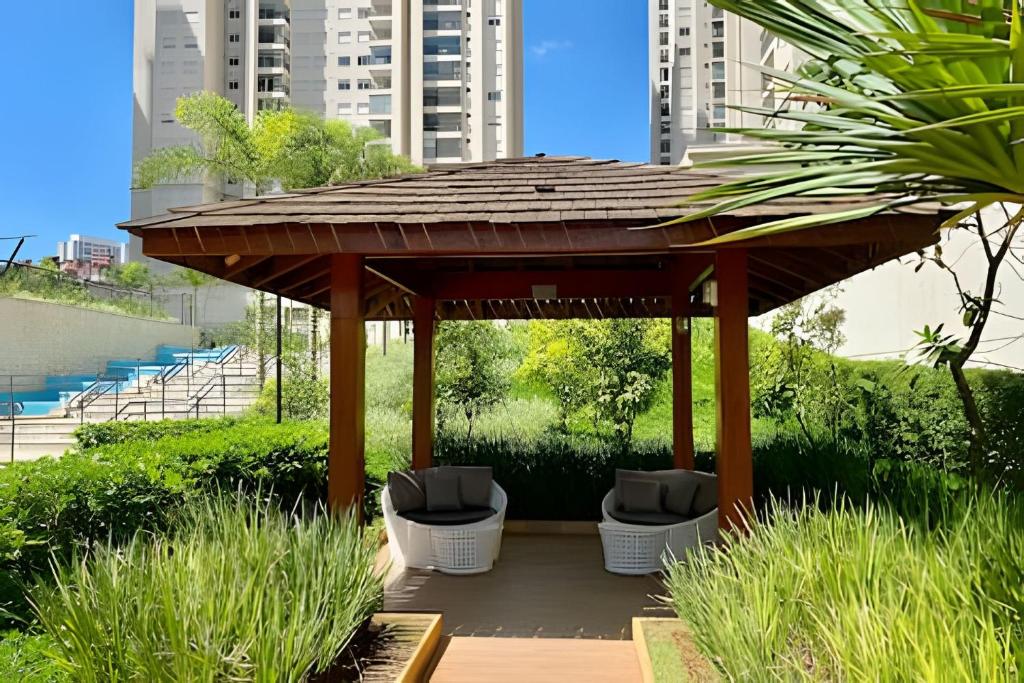 a wooden gazebo with chairs in a garden at 0406 - Studio Refúgio Cidade Maia in Guarulhos