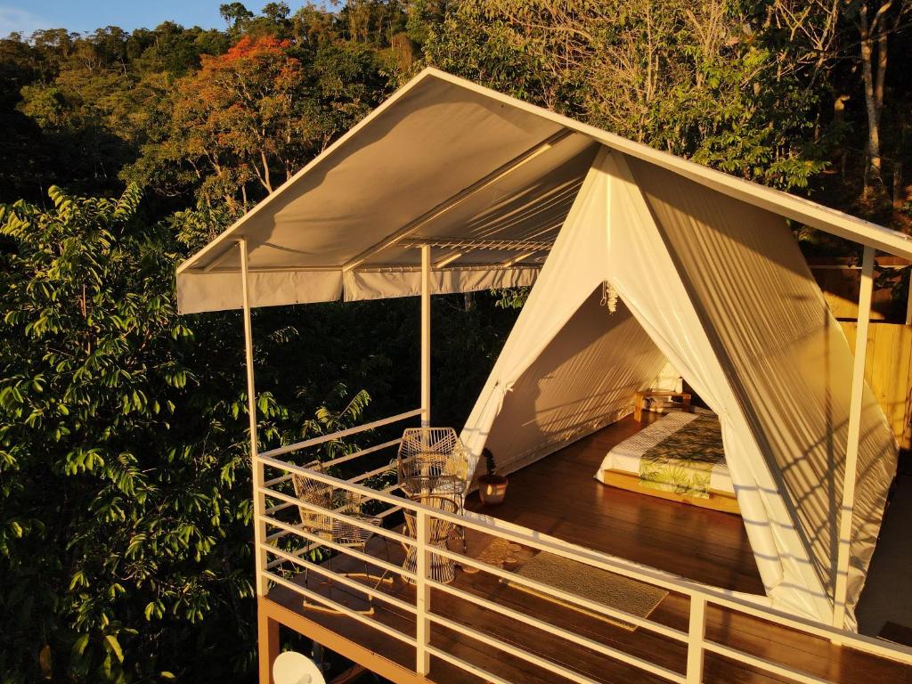 une tente au-dessus d'une terrasse en bois dans l'établissement Quimera Glamping, à Pacuar