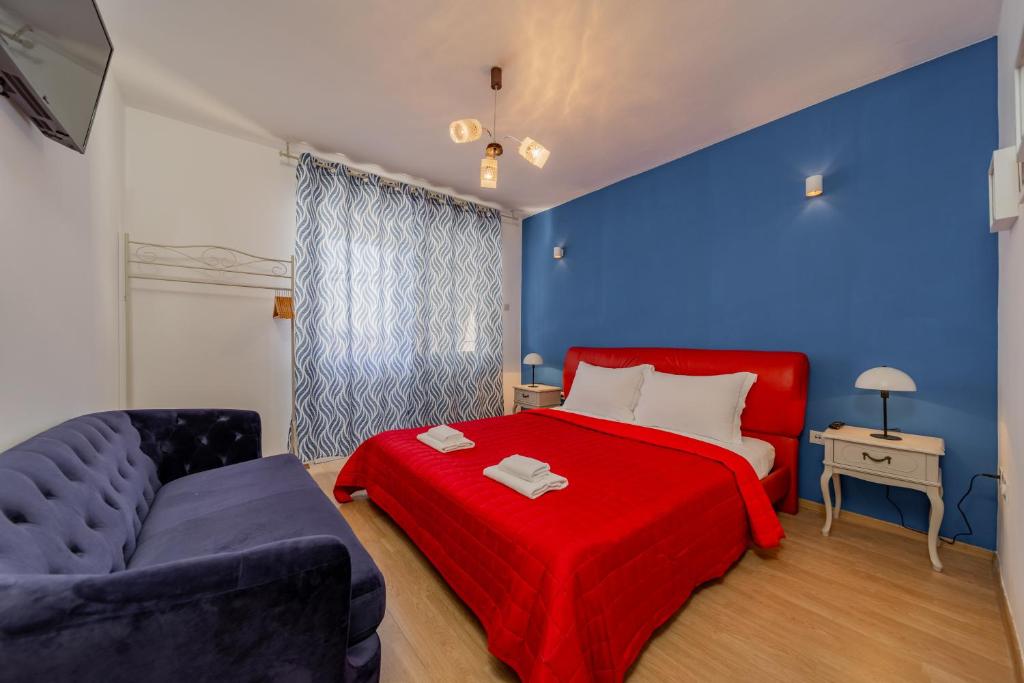 1 dormitorio con cama roja y pared azul en Villa Croatia Trogir, Center, 4 rooms, parking, jacuzzi, free beach and pool 15 min en Trogir