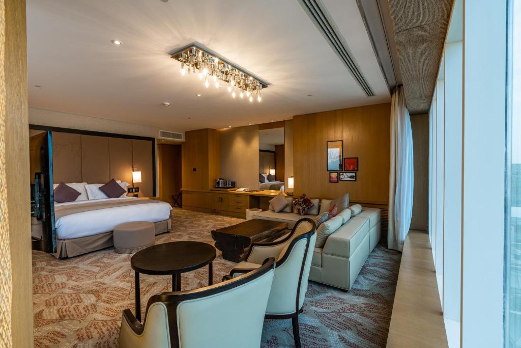 a hotel room with a bed and a living room at Al Anoud Tower Residence in Riyadh